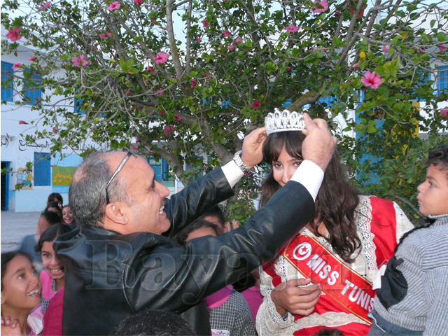 Le directeur de l'école Mr Jalel Ayayri, instituteur de la Miss au primaire, lui met la couronne. Une complicité digne d'un père et sa petite fille.